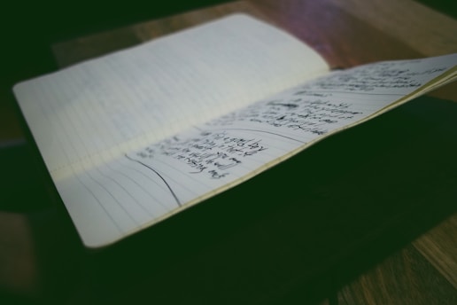 A focused professional writing notes in a bright, organized workspace.