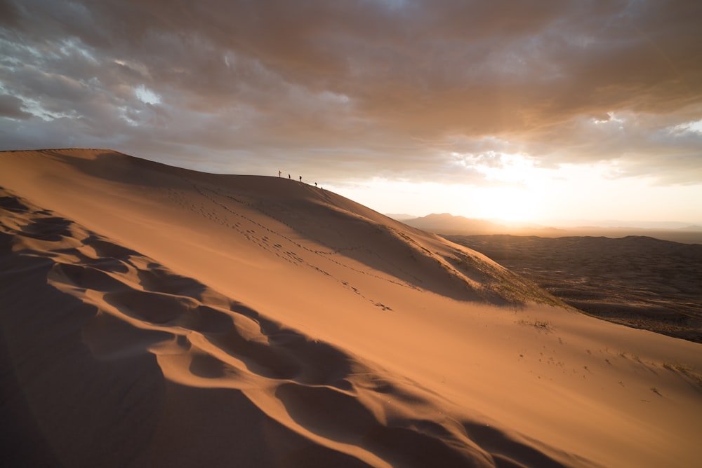 Grupo de personas que caminan en el desierto durante el amanecer