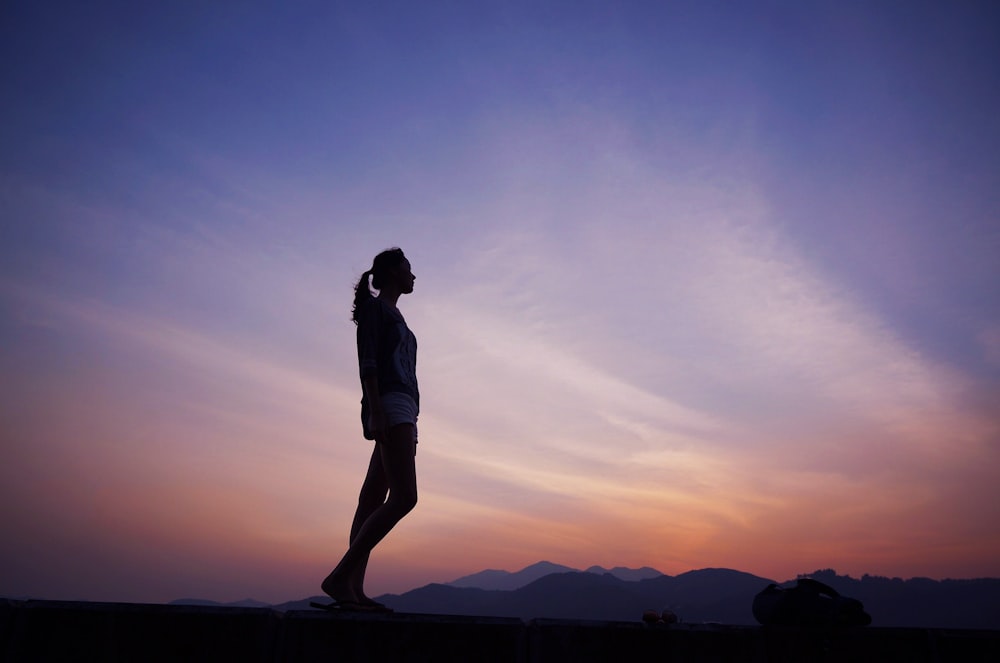 Mujer de pie bajo el cielo azul