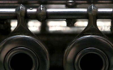 Close-up of a shiny steel bearing resting on a blueprint grid background with silver lines.