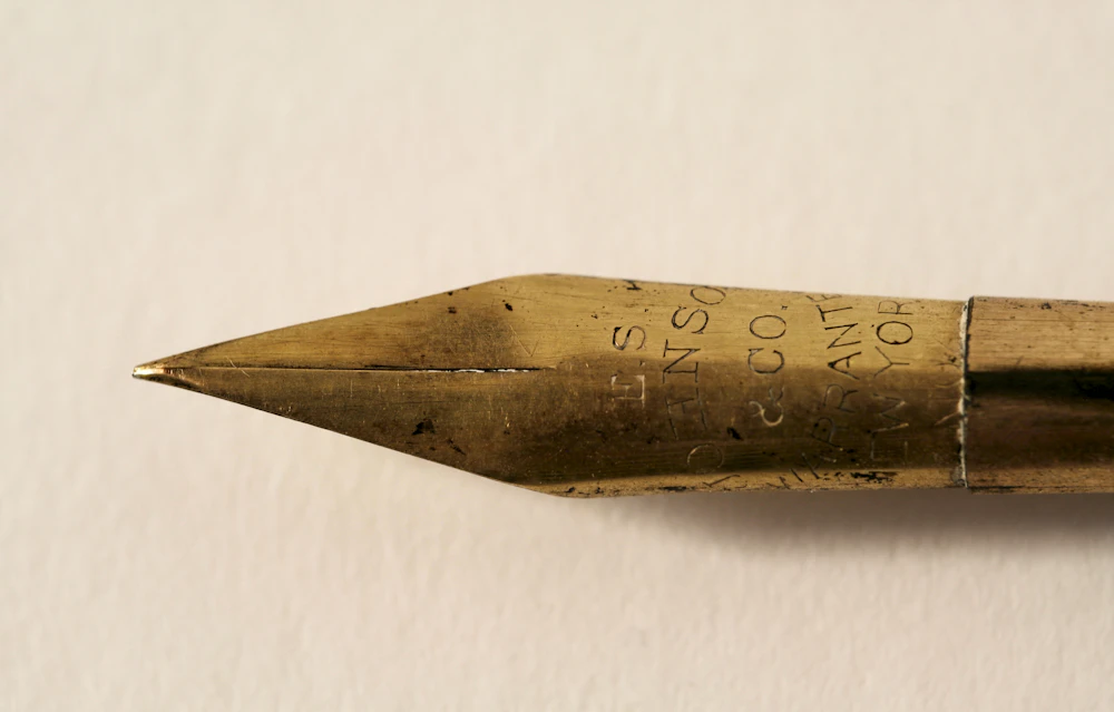 A gold fountain-pen nib — the instrument of the trade