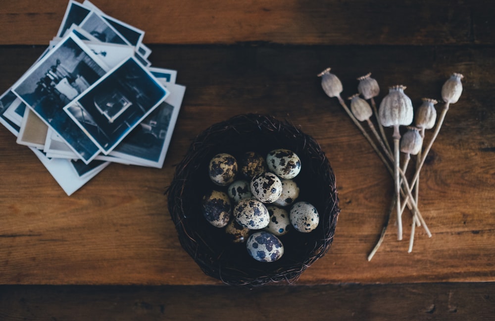 white-and-black quail eggs on brown wicker bowl