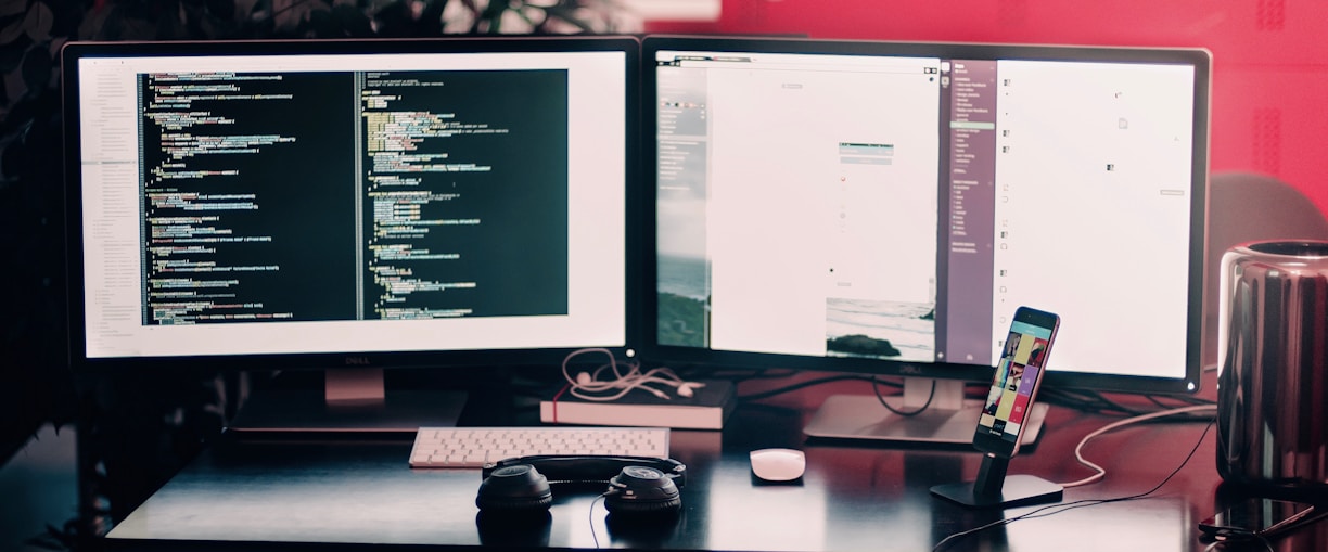 two black computer monitors on black table