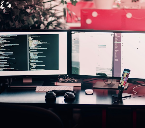 two black computer monitors on black table