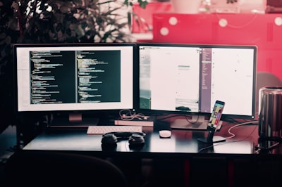 Co to jest strona internetowa? - two black computer monitors on black table