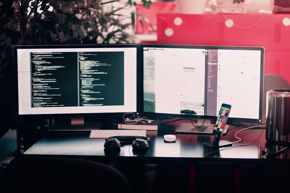 A two-display workspace with lines of code on one of the monitors