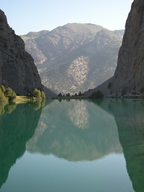 A tranquil scene of a calm lake reflecting mountains.