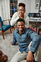 A smiling caregiver helping a patient with mobility exercises in a cozy living room.