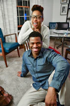 Team members assembling furniture with smiles in a warmly lit home setting.