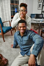 man sitting on floor beside woman smiling inside white painted room