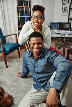Team members assembling furniture with smiles in a warmly lit home setting.