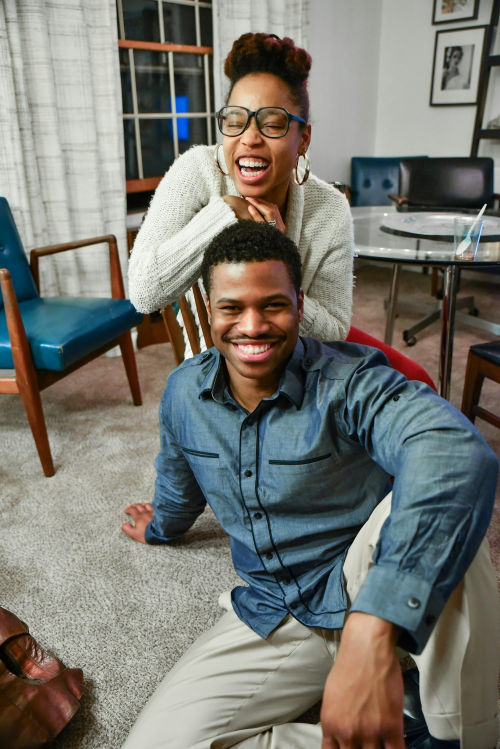 man sitting on floor beside woman smiling inside white painted room