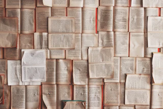 A wall of open books laid flat so their printed pages cover the entire surface