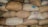 A close-up of various grains in burlap sacks displayed in a warehouse.