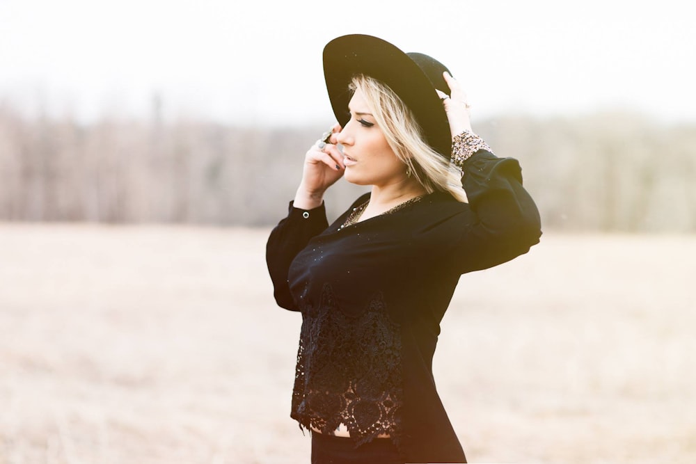 woman holding black hat