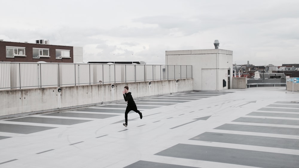 person running on concrete lot during daytime