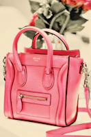 Blush pink sling bag hanging on a modern chair against a soft beige background.