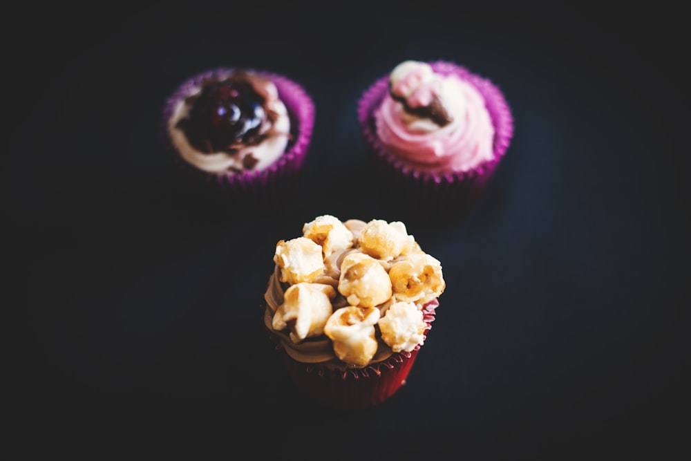 three closeup photography of three cupcakes