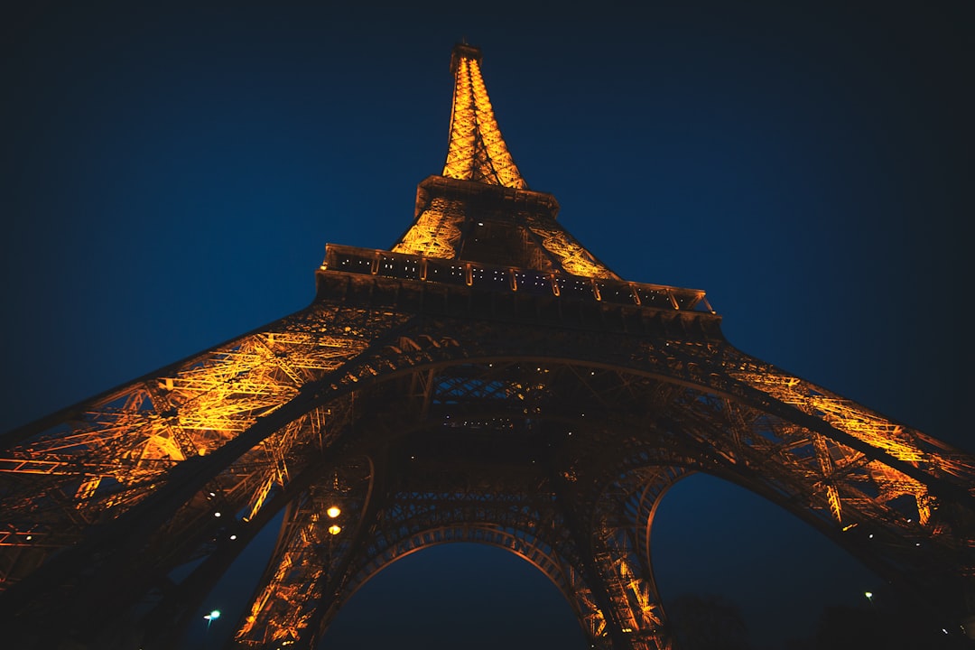Looking up at the Eiffel Tower illuminated at night in Paris
