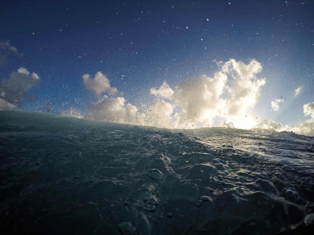 Staring out into the ocean with fluffy white clouds in the horizon.