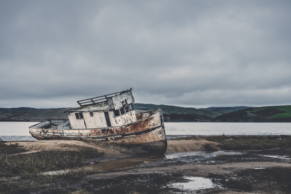 stacked boat near sea under white sky