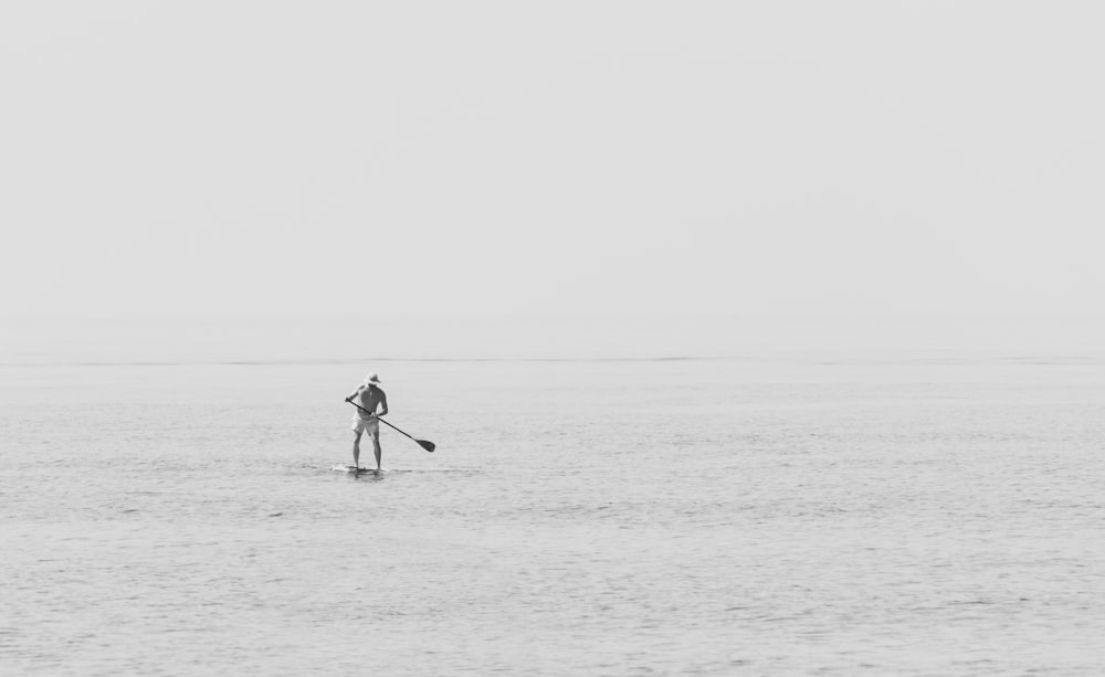 man standing on paddleboard