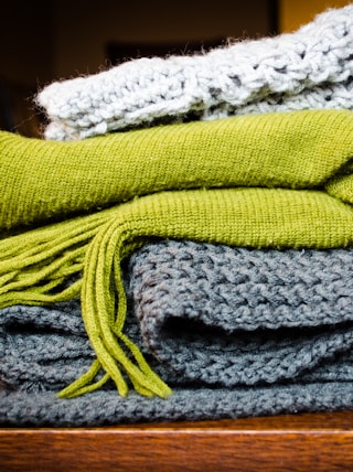 three gray, green, and white scarf on top of table