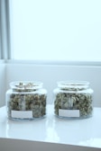 full of kush in clear glass jars on table