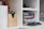 Modern home office featuring a sleek shelf holding office supplies and decorative items.