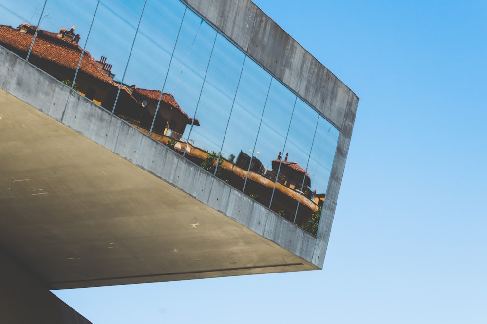 Edificio grigio con finestre di vetro a specchio durante il giorno