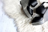 pair of women's black-and-gray wedges on white fur textile