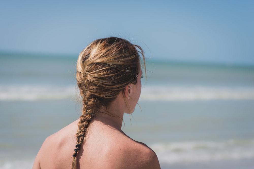 back view photo of woman with braided hair near sea