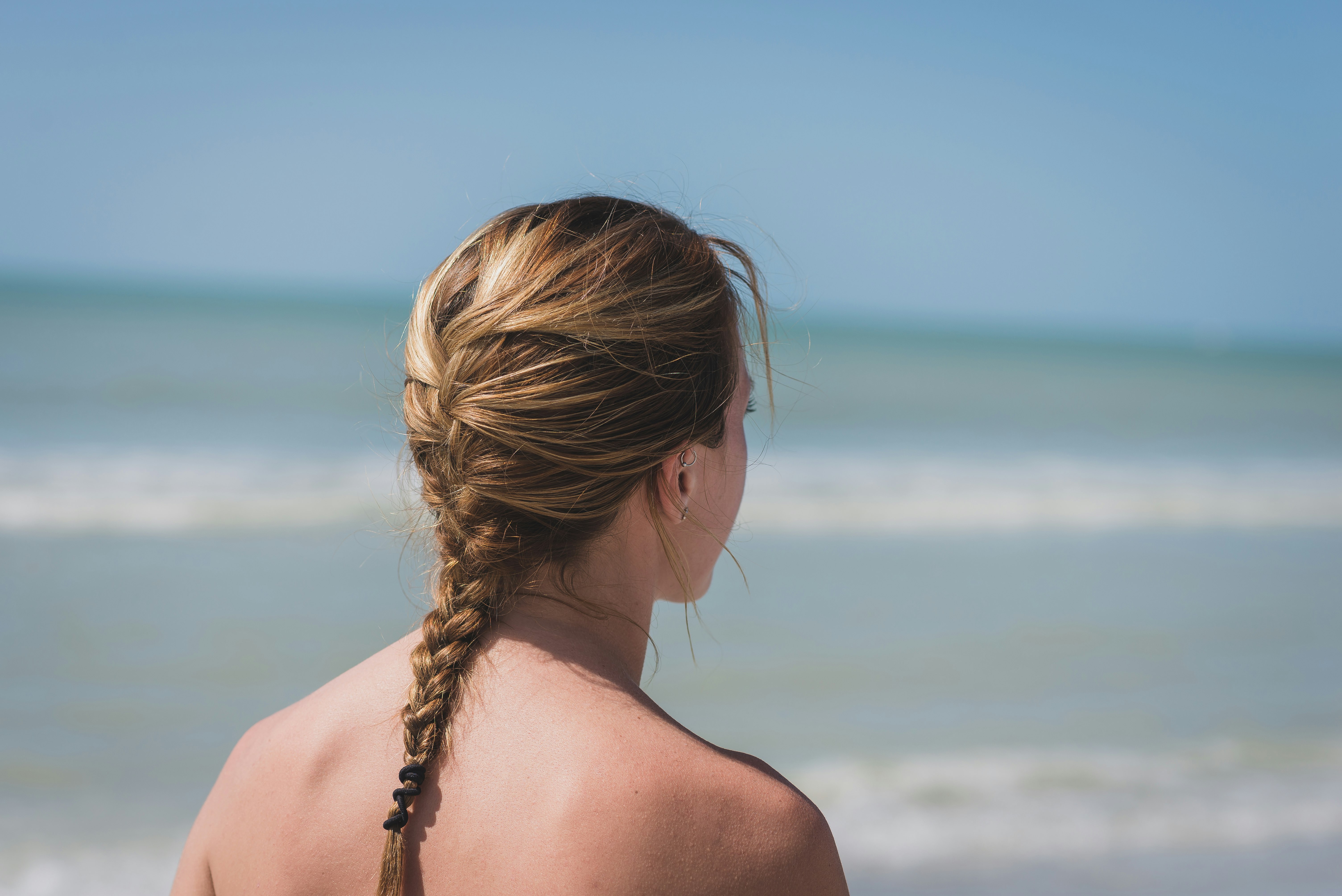back view photo of woman with braided hair near sea