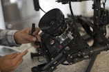 A crew member adjusting camera equipment.