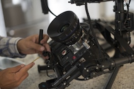 Technician repairing a security camera with tools in hand.