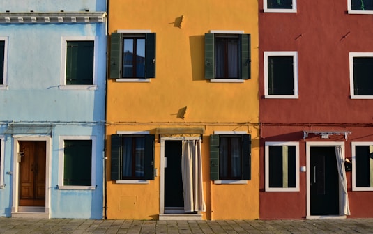 minimalist photography of open doors and windows of colored buildings