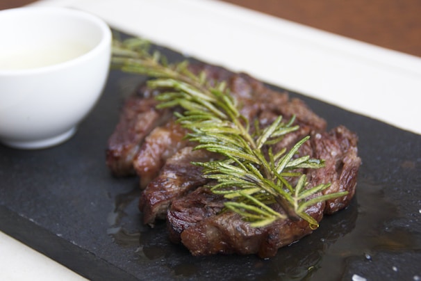 A spoonful of vibrant green chimichurri sauce dripping over a perfectly grilled steak