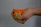 Hand holding a mini chopper with chopped vegetables inside on kitchen counter