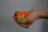 Hand holding a mini chopper with chopped vegetables inside on kitchen counter