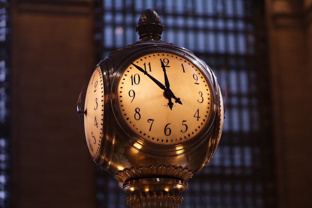 turned on brass-colored train station analog clock,