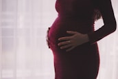 An obstetrician consulting with a pregnant woman in a calm, private examination room.