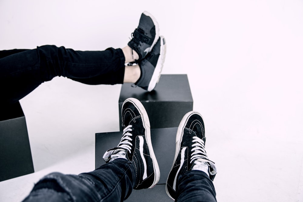 pair of white-and-black Vans high-top sneakers