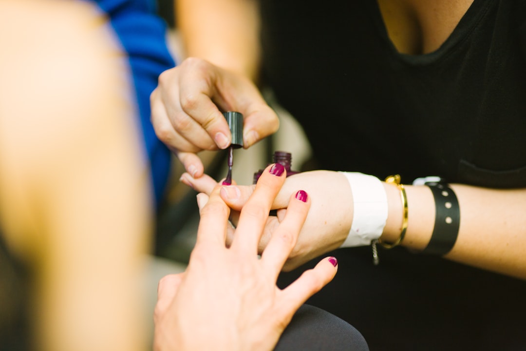 A woman getting her nails painted by a beautician.