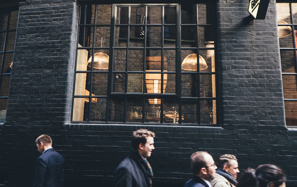 people standing beside black building