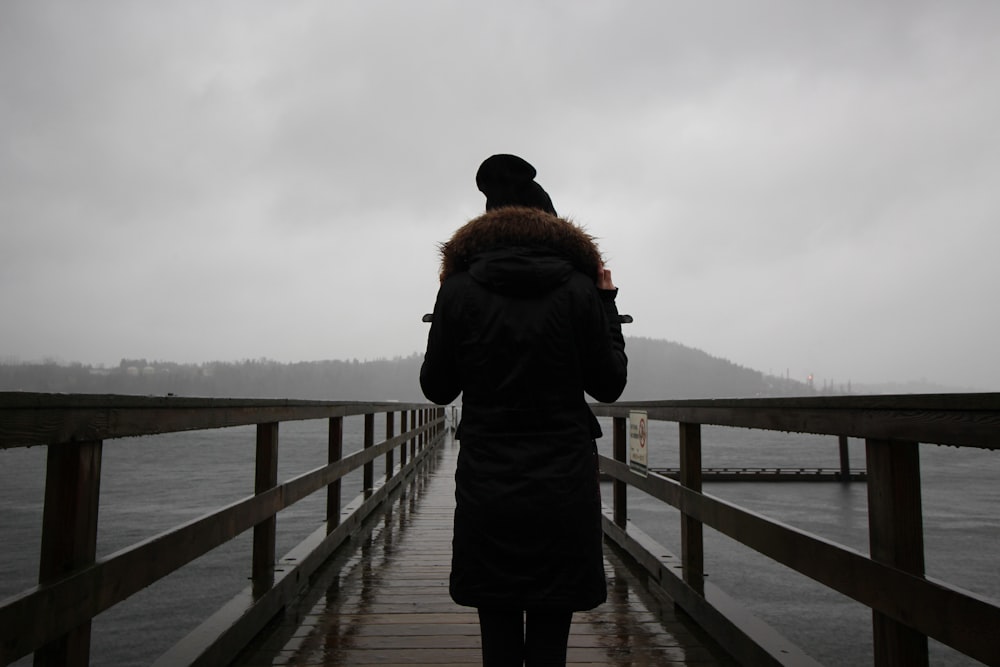 woman on dock near lake