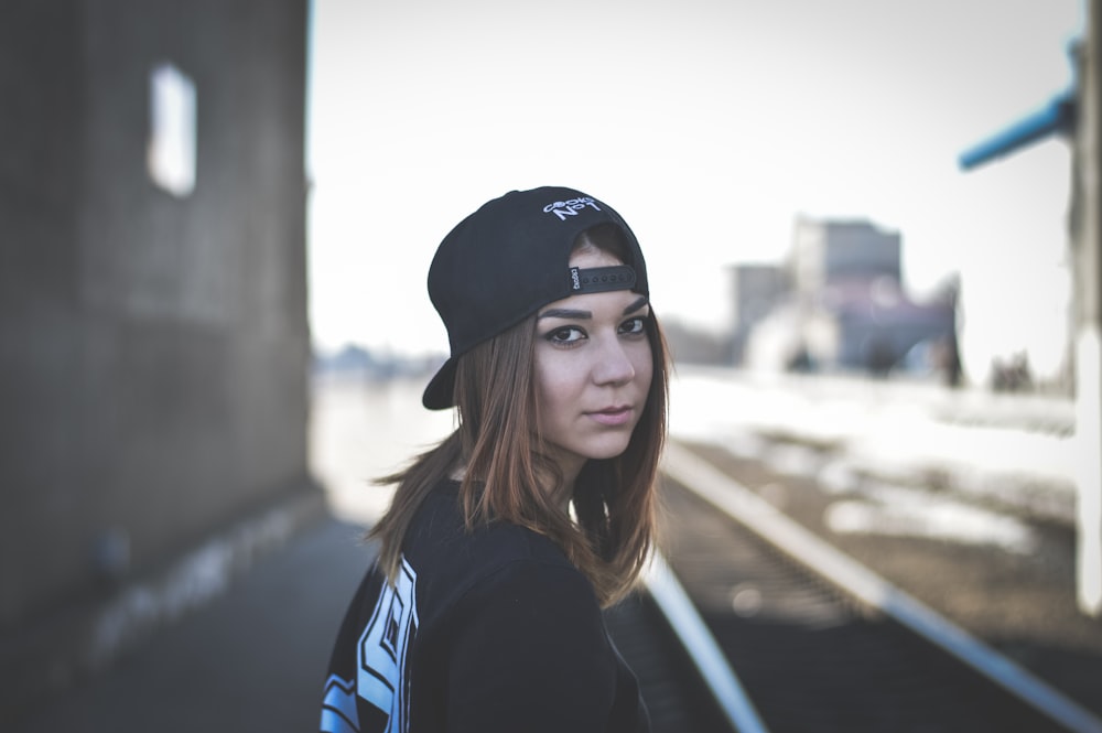 woman wearing black snapback cap looking back