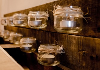 Elegant wedding favor candles in small glass jars tied with rustic twine and personalized tags.