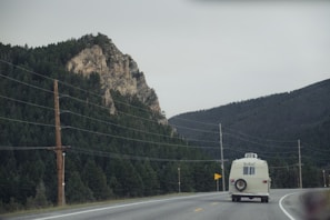 Voyagecraft caravan driving along a winding mountain road under clear blue skies