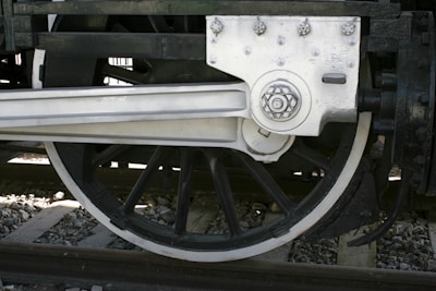 A close-up of precision-engineered train wheels on a railway track.