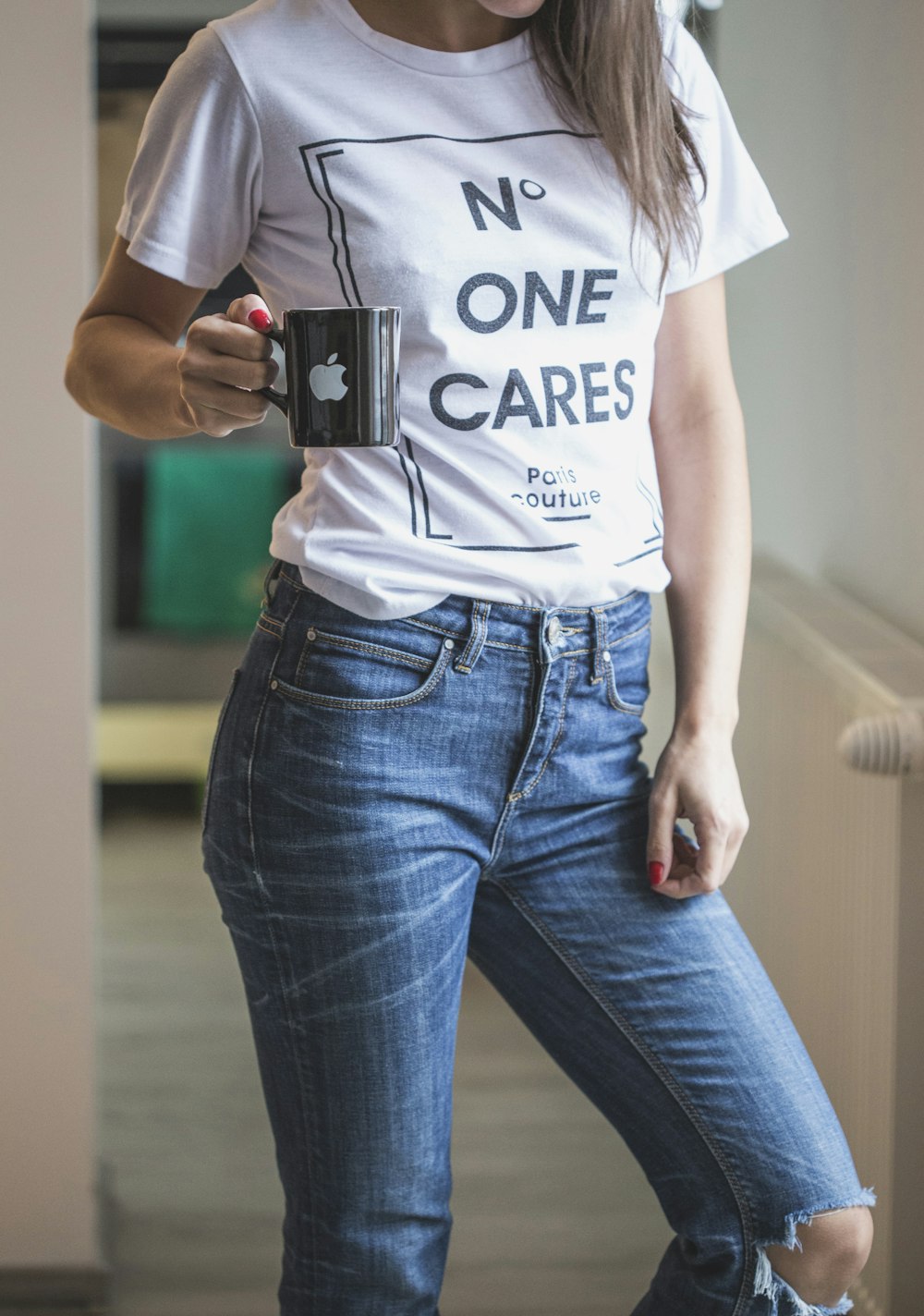 woman in white crew neck t-shirt and blue denim jeans holding black camera